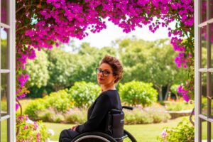 Femme en fauteuil roulant et cumul AAH pension de réversion 2026 | Pension de reversion Femme épanouie en fauteuil roulant dans un jardin, illustrant le cumul AAH et pension de réversion en 2026