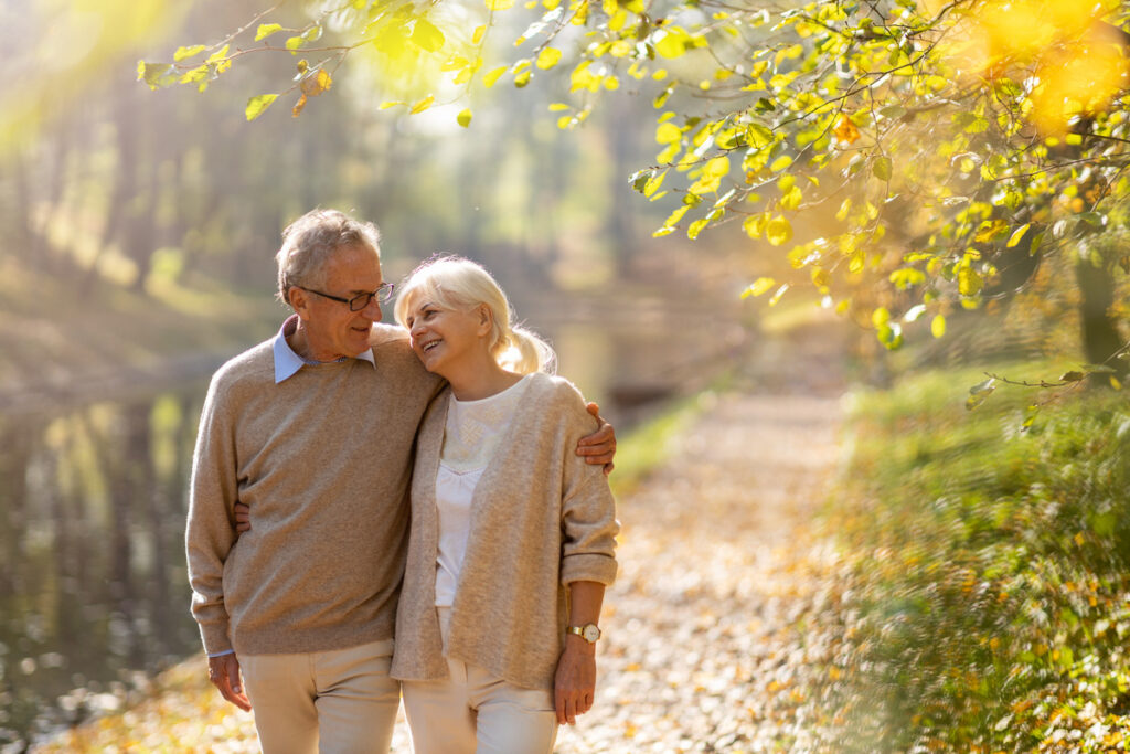 Couple de seniors heureux se promenant | Pension de reversion Couple de seniors heureux profitant de leur retraite illustrant le droit au remariage et à la pension de réversion
