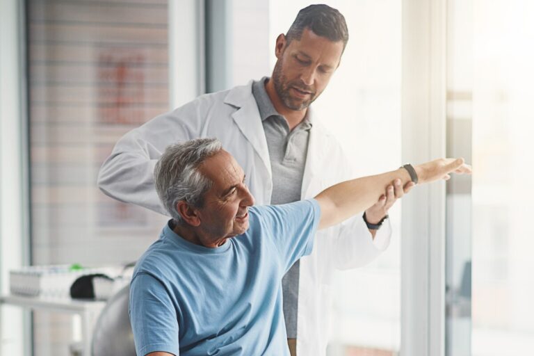 Un médecin effectuant un test de mobilité sur un patient senior dans le cadre de la reconnaissance de l'inaptitude au travail pour la retraite.