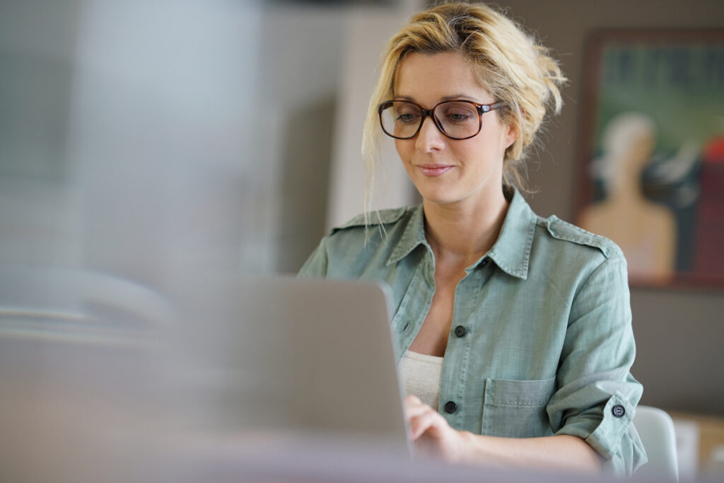 Retraite des mères de famille : anticiper ses démarches en ligne | Pension de reversion Femme consultant son ordinateur pour préparer sa retraite des mères de famille