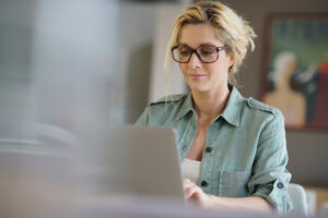 Retraite des mères de famille : anticiper ses démarches en ligne | Pension de reversion Femme consultant son ordinateur pour préparer sa retraite des mères de famille