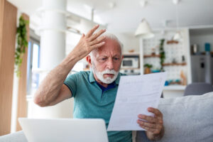 Simulateur Info-retraite : les pièges et erreurs de calcul | Pension de reversion Homme âgé perplexe analysant un document financier après une simulation sur Info-retraite