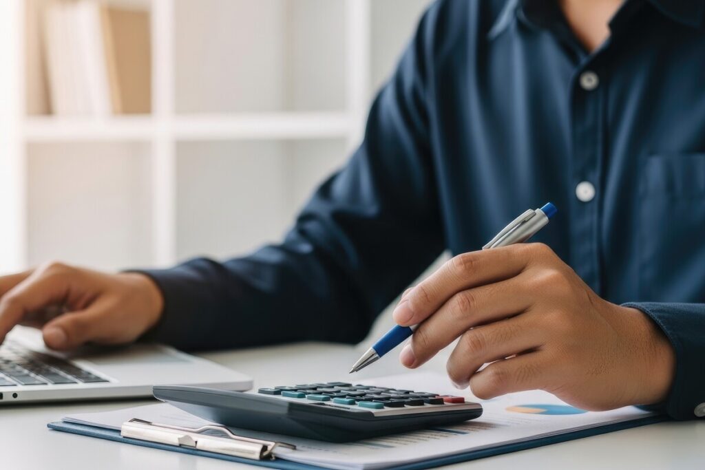 Personne effectuant un recalcul de la réversion avec une calculatrice et des documents financiers