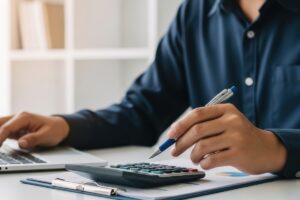 Personne effectuant un recalcul de la réversion avec une calculatrice et des documents financiers