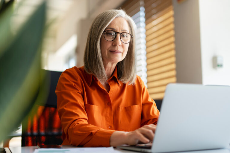 Femme consultant son ordinateur pour le suivi de réversion de sa retraite