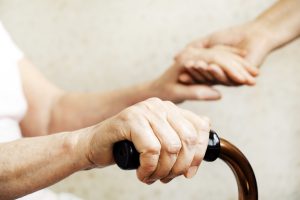 Femme âgée handicapée tenant main aide