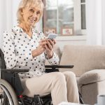 Femme âgée retraitée handicapée fauteuil roulant au téléphone