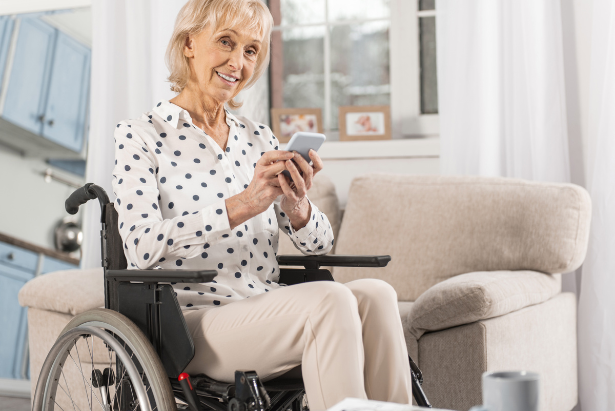 Femme âgée retraitée handicapée fauteuil roulant au téléphone