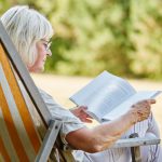 Femme retraitée veuve allongée hamac lisant livre