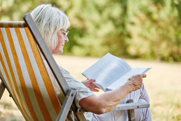 Femme retraitée veuve allongée hamac lisant livre