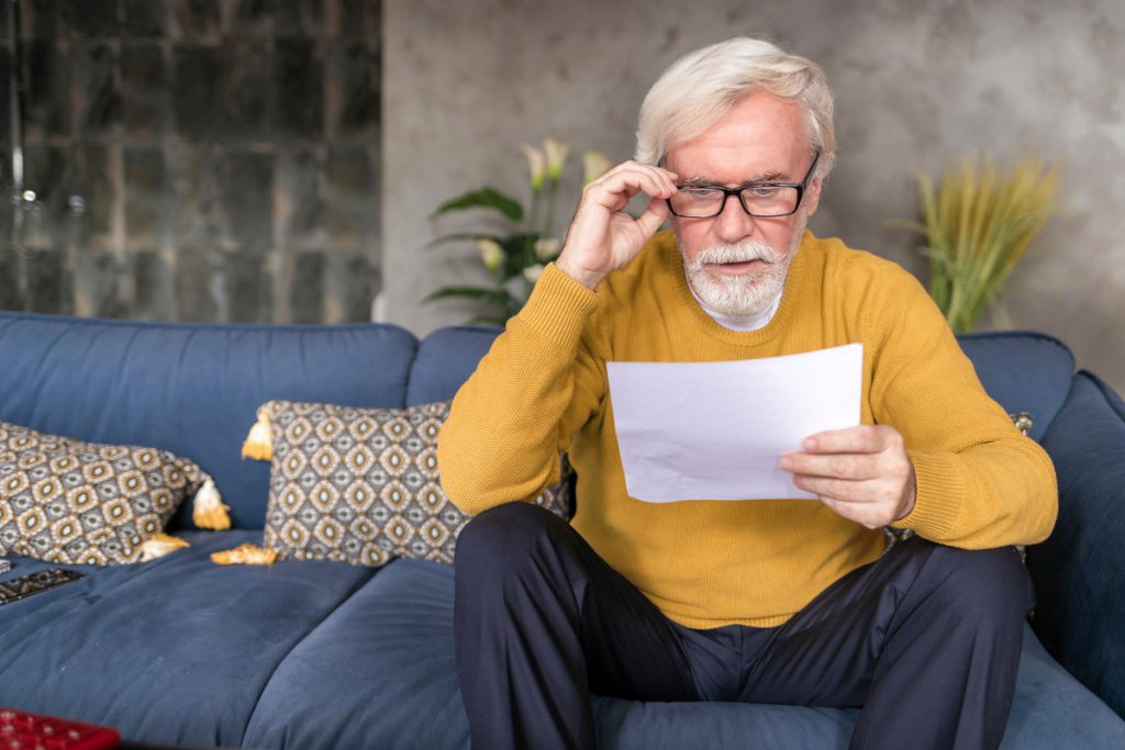 homme retraité mécontent lisant lettre organisme retraite