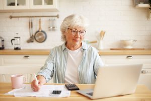 Femme retraité devant ordinateur calculette