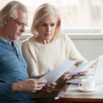 Couple personnes âgés lisant contrat assurance vie