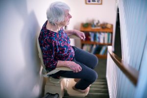 femme âgée assise sur un monte-escalier