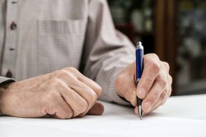 Homme écrivant une lettre de demande de pension de réversion