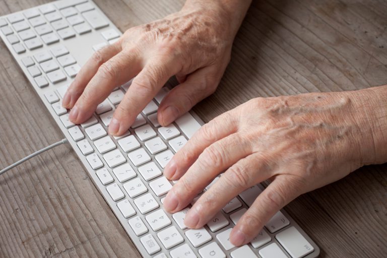 Mains femme âgée sur clavier ordinateur pension réversion